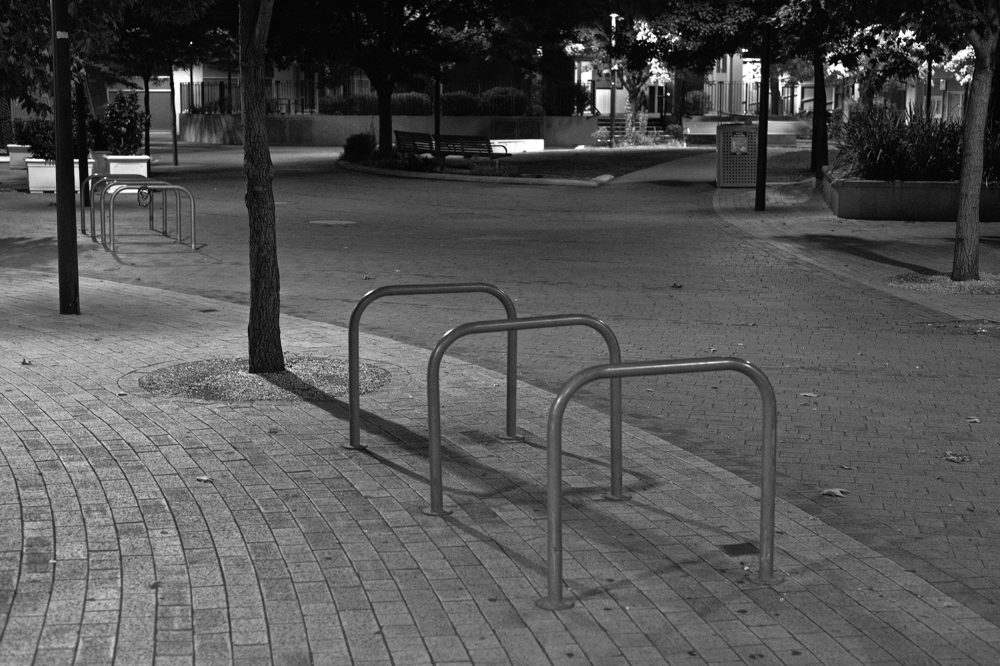 Empty street scene at night with bike racks in the foreground