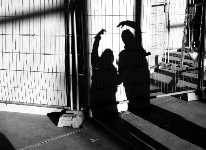 Shadows of two women creating an arc on a wall