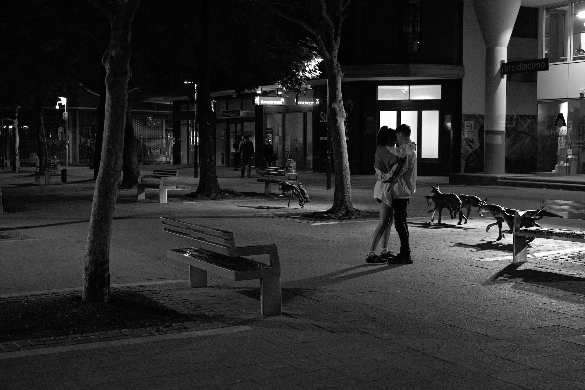 Couple hugging in a street at night