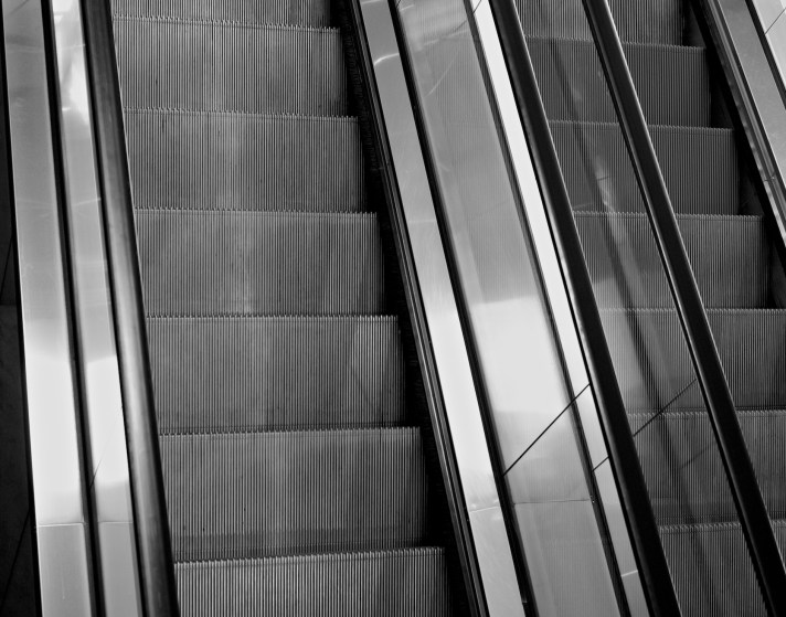 Photo of two escalators that both appear to be going in the same direction
