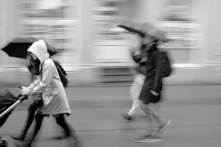 Photo of people walking in the rain carrying umbrellas