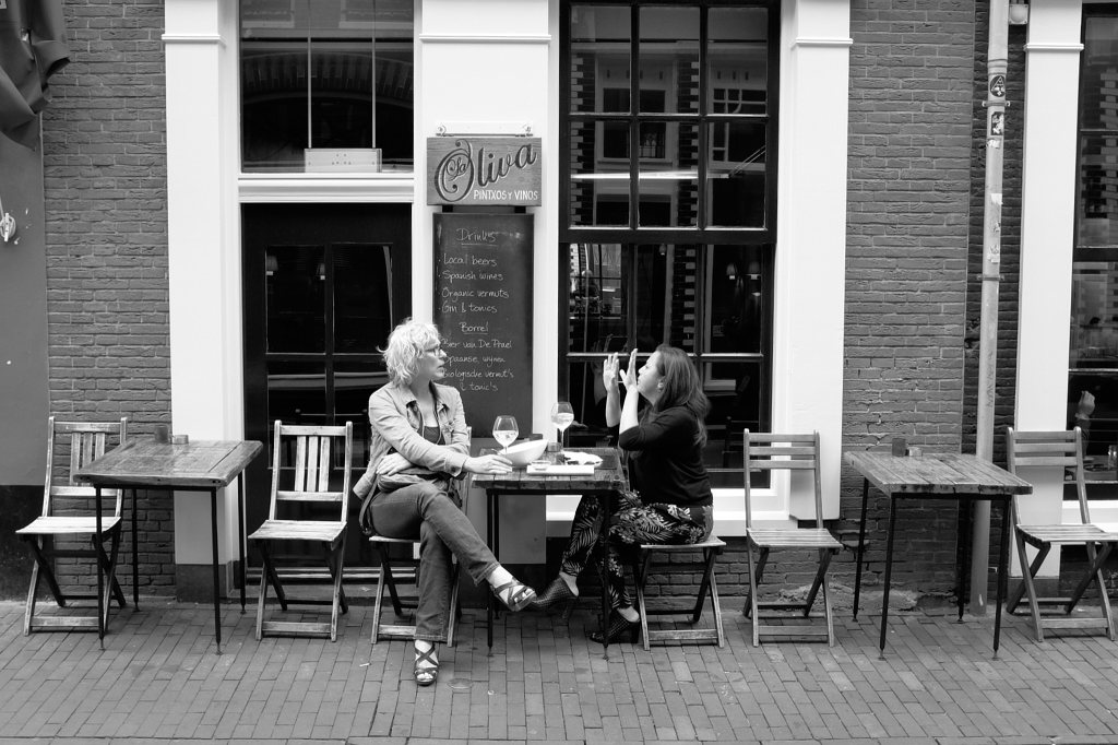 Two people in a cafe sharing a story with one person using expressive hand movements