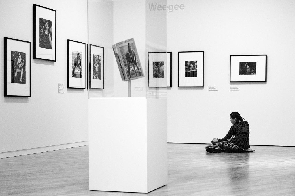 Woman sitting on the floor of 'great' public gallery contemplating the art works.